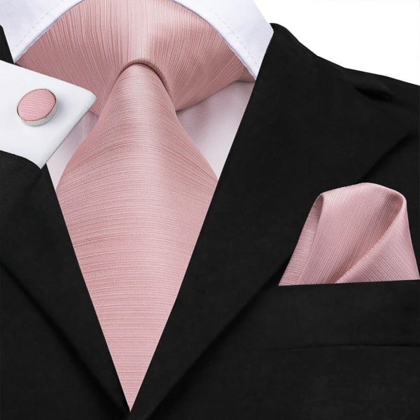 Baby pink rose gold silk tie displayed on a suit