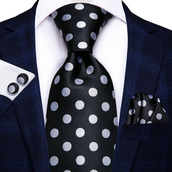 Black white polka dot silk tie displayed on a suit