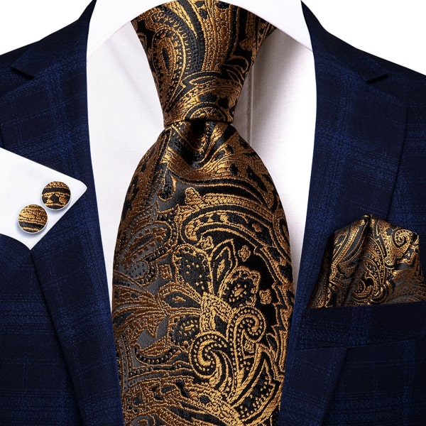 Gold black paisley silk tie displayed on a suit