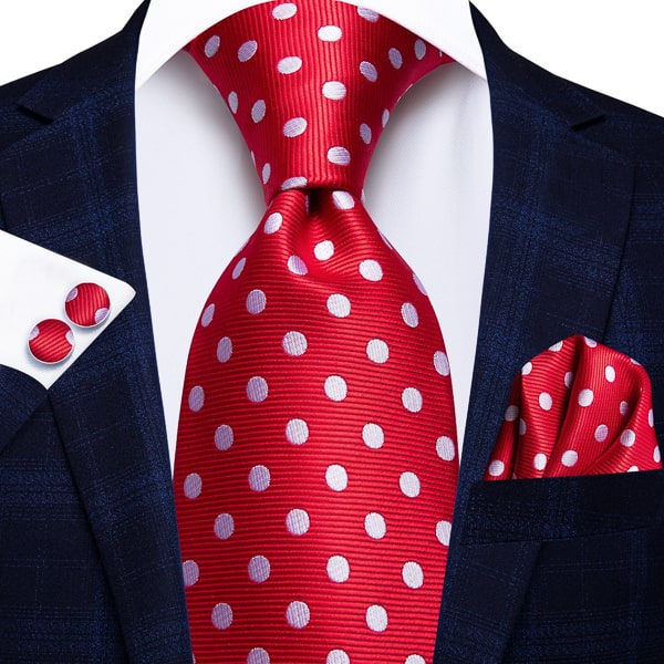 Red white polka dot silk tie displayed on a suit