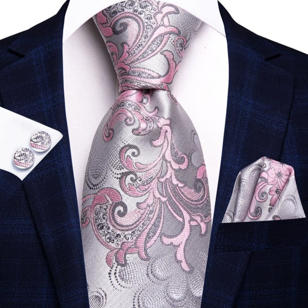 Silver pink floral silk tie displayed on a suit