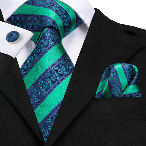 Green blue striped paisley silk tie set with a matching pocket square and cufflinks on a suit