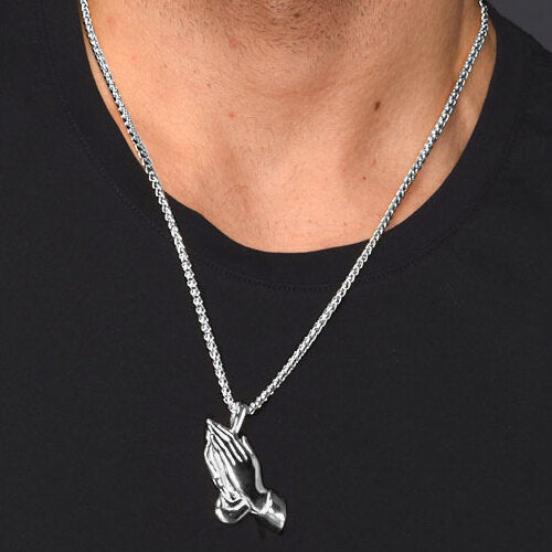 Man wearing a silver praying hands pendant necklace