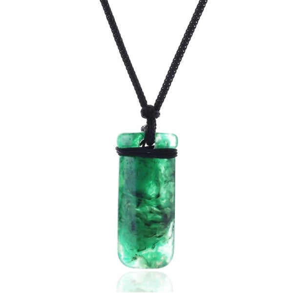 Green resin pendant hanging on a black rope necklace