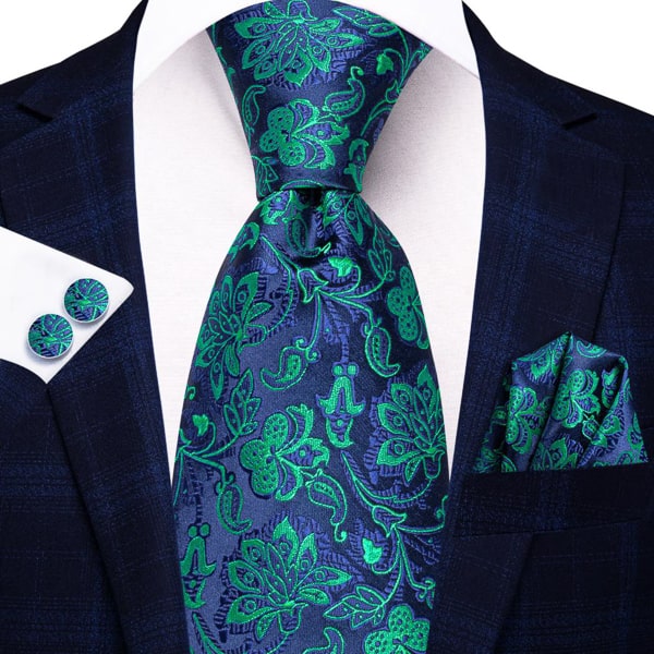 Blue green floral silk tie displayed on a suit