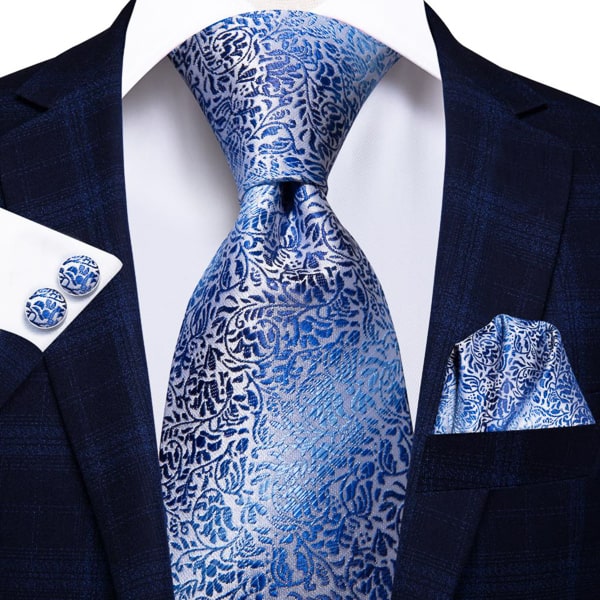 Blue silver floral silk tie displayed on a suit