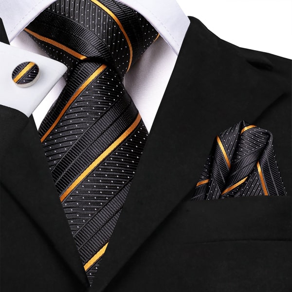 Carbon black gold striped silk tie displayed on a suit