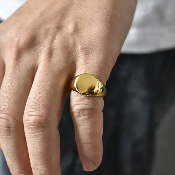 Gold pinky ring on a man's finger