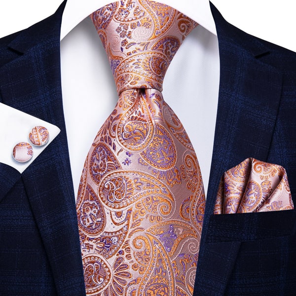 Orange purple paisley silk tie displayed on a suit