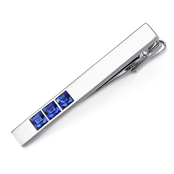 Silver tie clip with blue gemstones on a white background