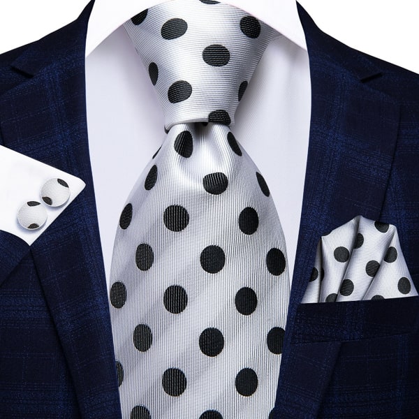 White black polka dot silk tie displayed on a suit