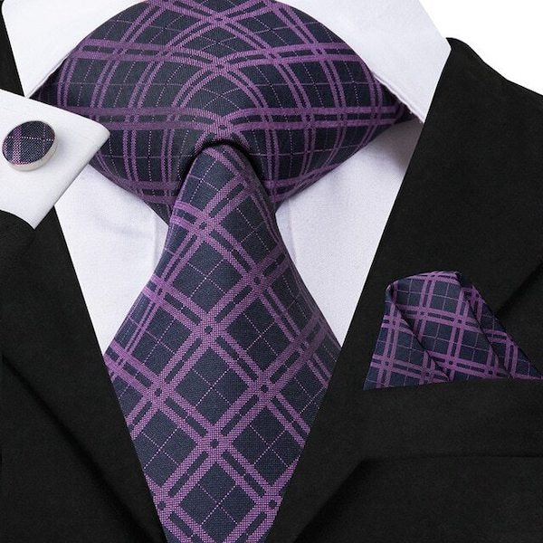 Man wearing a black and purple tartan check silk tie set with matching pocket square and cufflinks