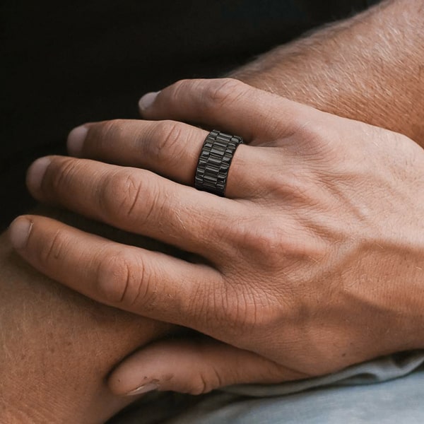 Man wearing a black wide band ring