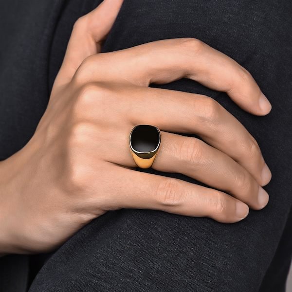 Man wearing an elegant gold ring with black stone