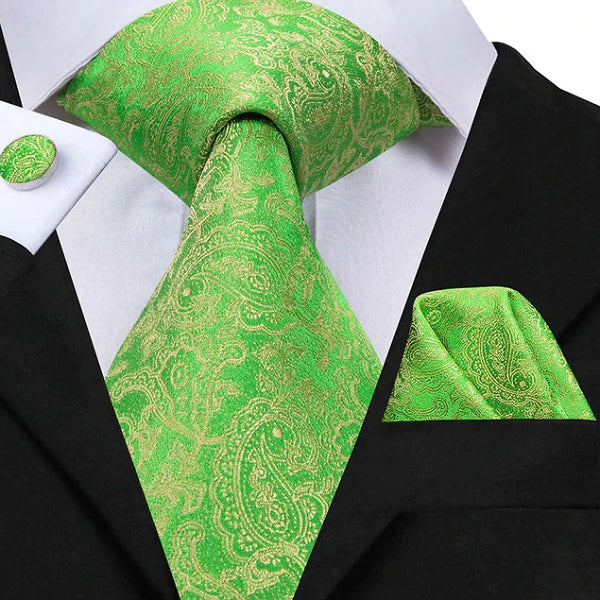Green & gold paisley silk tie set displayed on a suit
