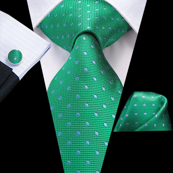 Green silk polka dot tie set with a matching pocket square and cufflinks on a suit