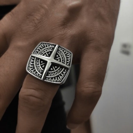 Man wearing a large compass signet ring