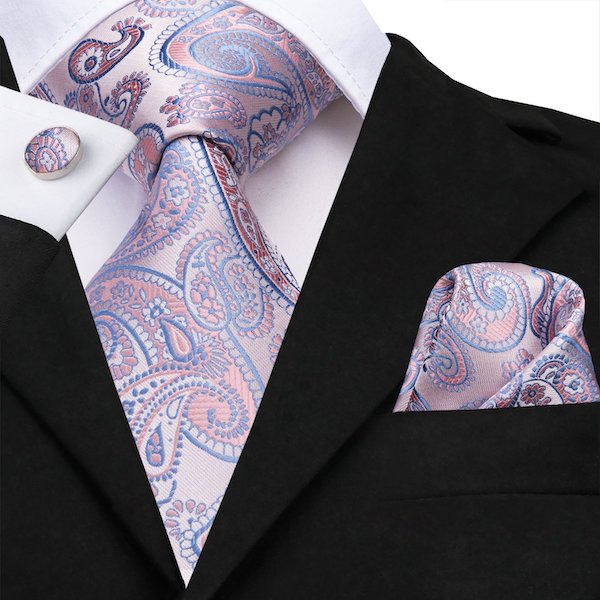 Man wearing a lavender purple paisley silk necktie and a matching pocket square and cufflinks