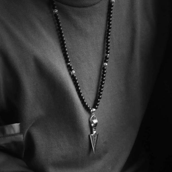 Man wearing a long black beaded arrowhead necklace