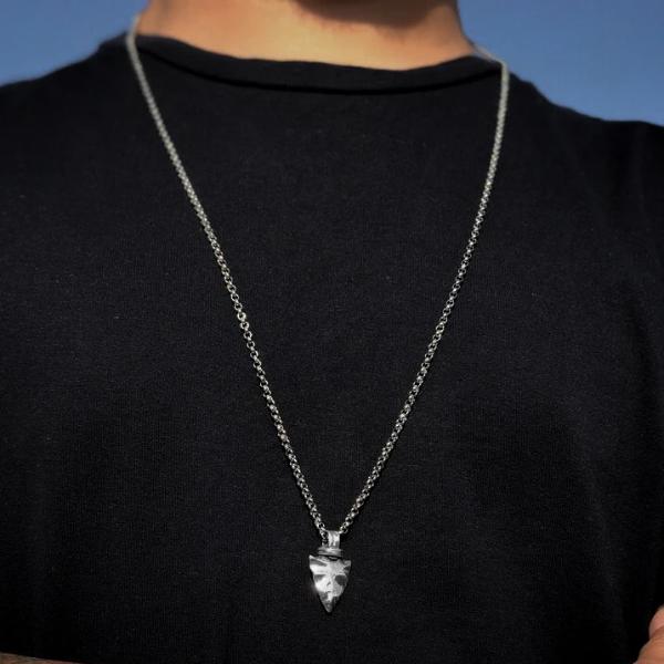 Man wearing a silver spearhead pendant necklace