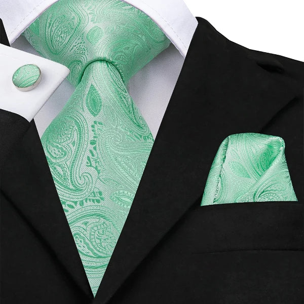 Mint green silk floral paisley tie set displayed on a suit