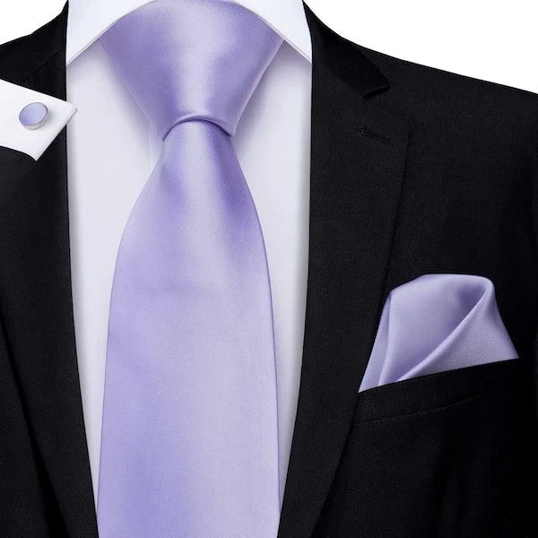 Man wearing a plain lavender silk tie with matching pocket square and cufflinks