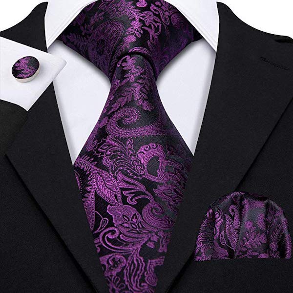 Man wearing a purple and black silk tie set with paisley floral pattern