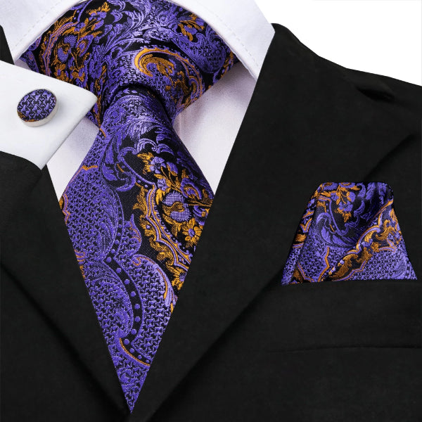 Man wearing a purple and gold floral tie with a matching pocket square and cufflinks