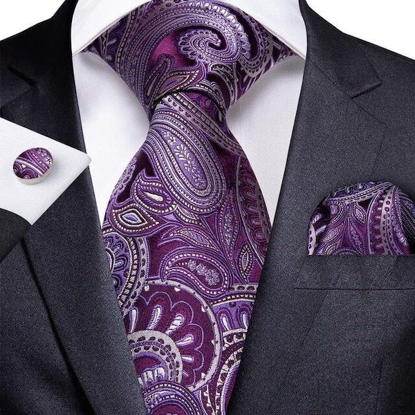 Man wearing a purple and ivory white paisley silk tie set with matching pocket square and cufflinks