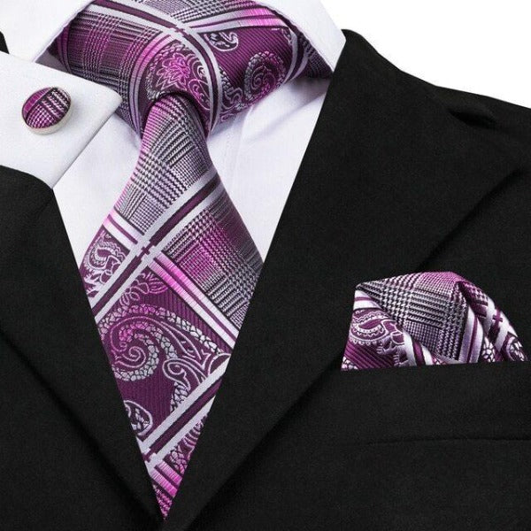 Man wearing a purple silk tie set with paisley, tartan check, and gradient stripe pattern