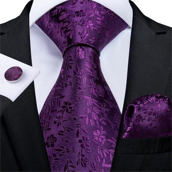 Man wearing a royal purple floral silk tie with matching pocket square and cufflinks