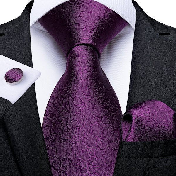 Man wearing a royal purple silk necktie with matching pocket square and cufflinks