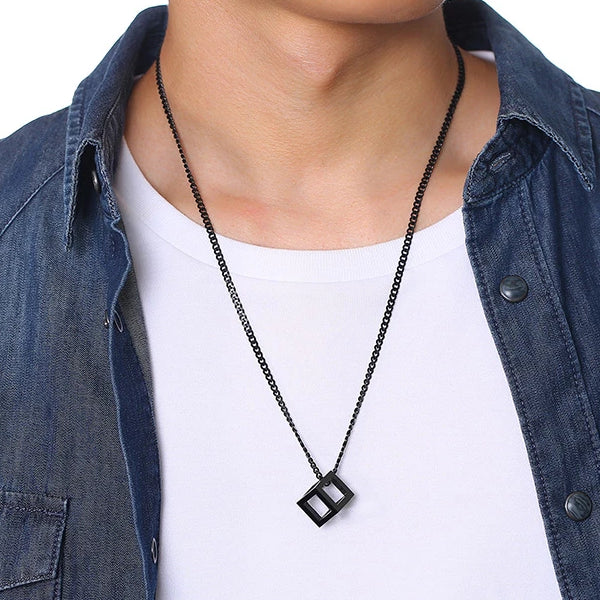 Man wearing a black cube pendant necklace for men