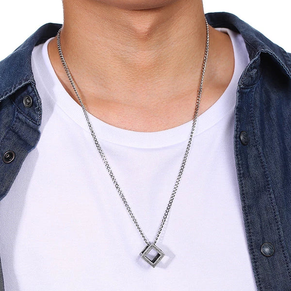 Man wearing a worn metal cube pendant necklace for men